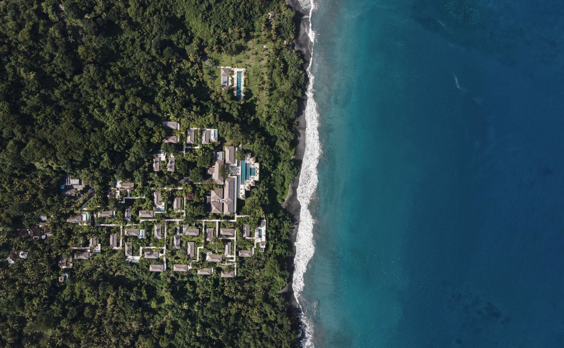 Aerial view of Amankila’s palm-covered hillside and the blue waters of Bali